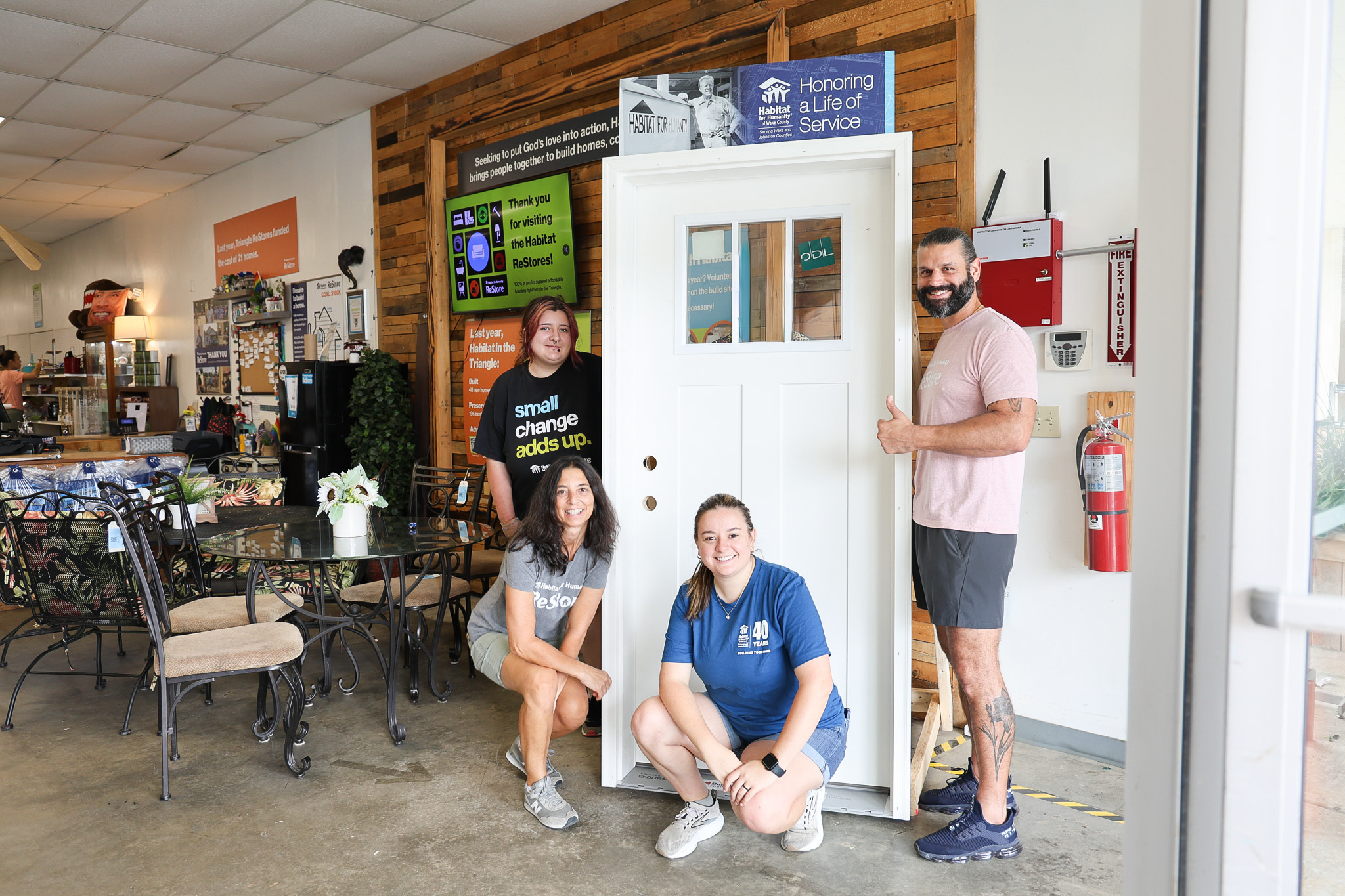 Apex ReStore team stand in front of Jimmy Carter Legacy Door at the Apex ReStore