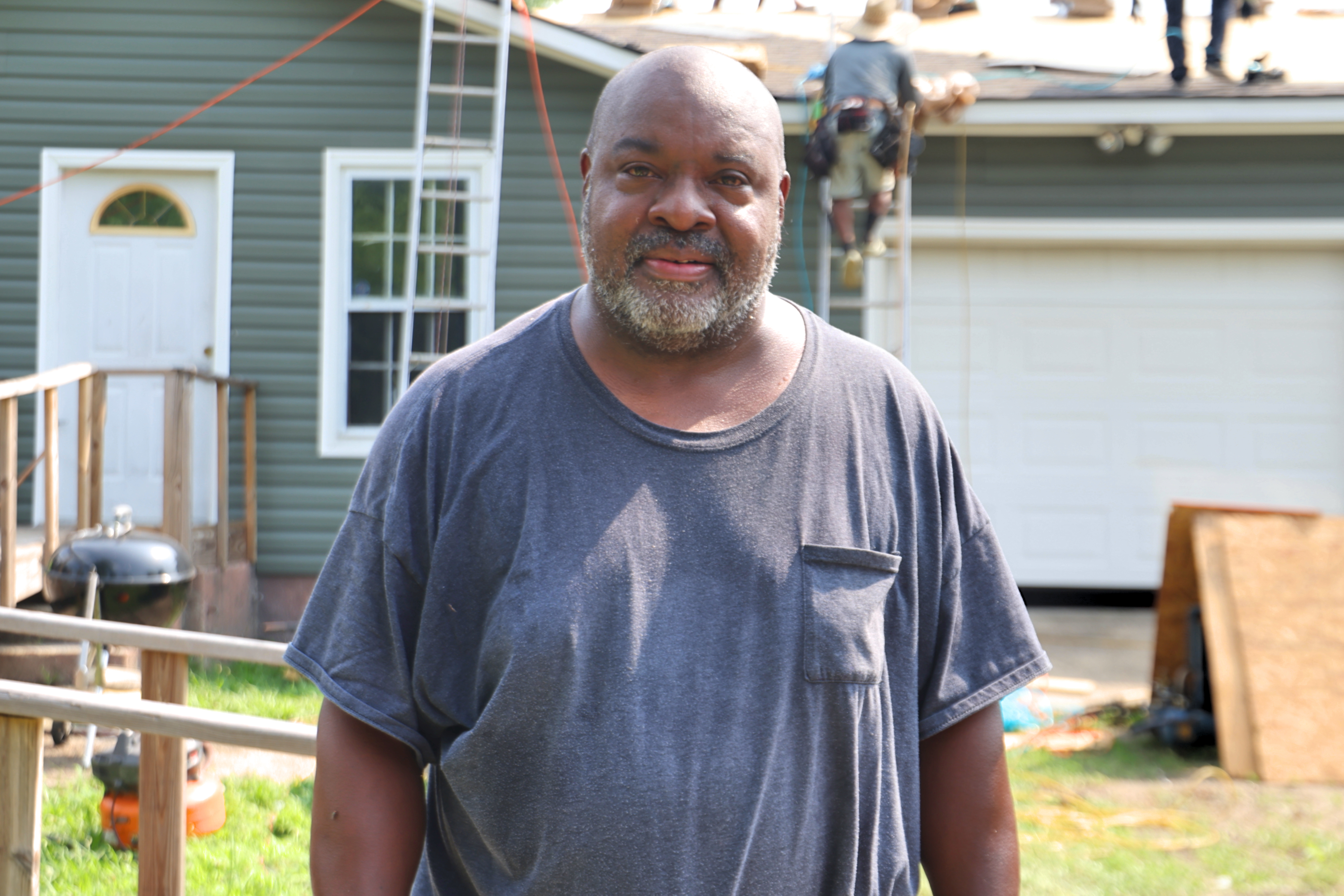 Anthony Woods standing outside of his home