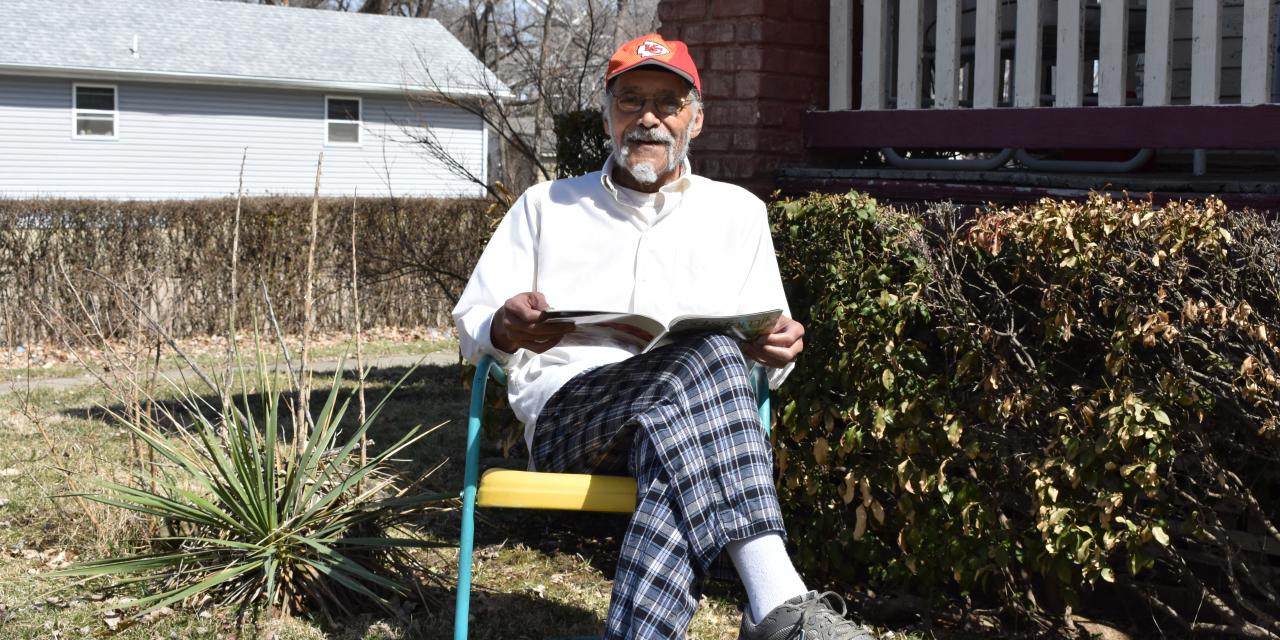 Elderly man in front of his home