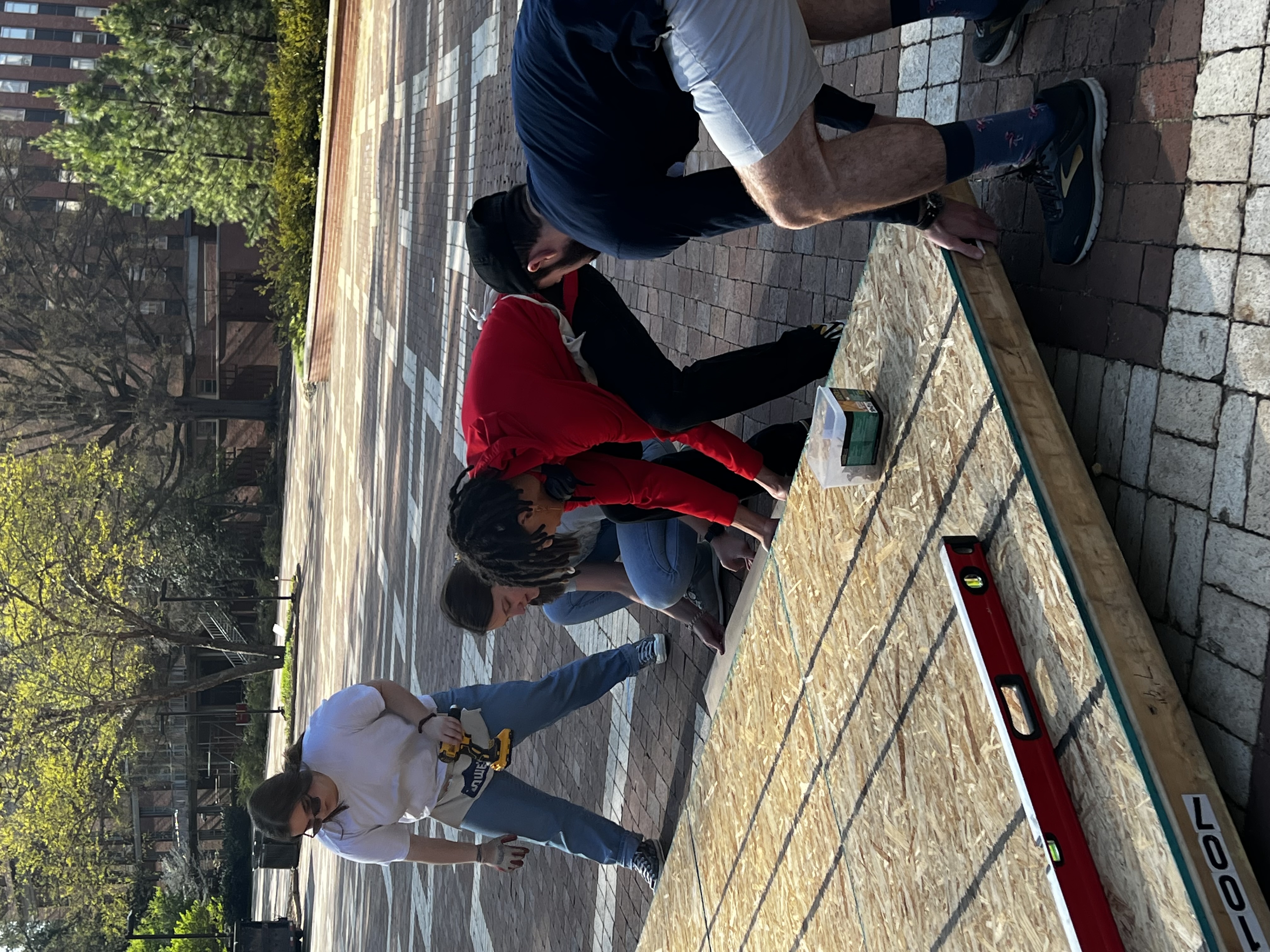 Students raising a wall of a shack