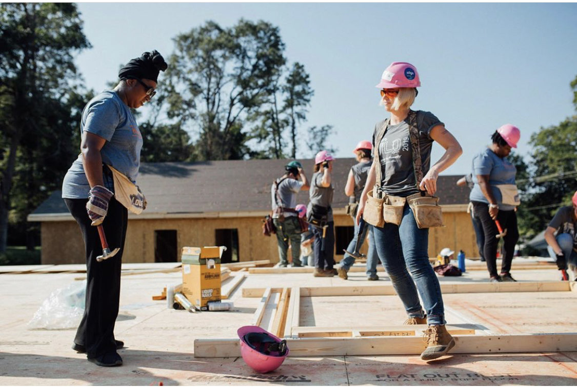 Habitat Wake Women Build board chair on a build site with a homebuyer