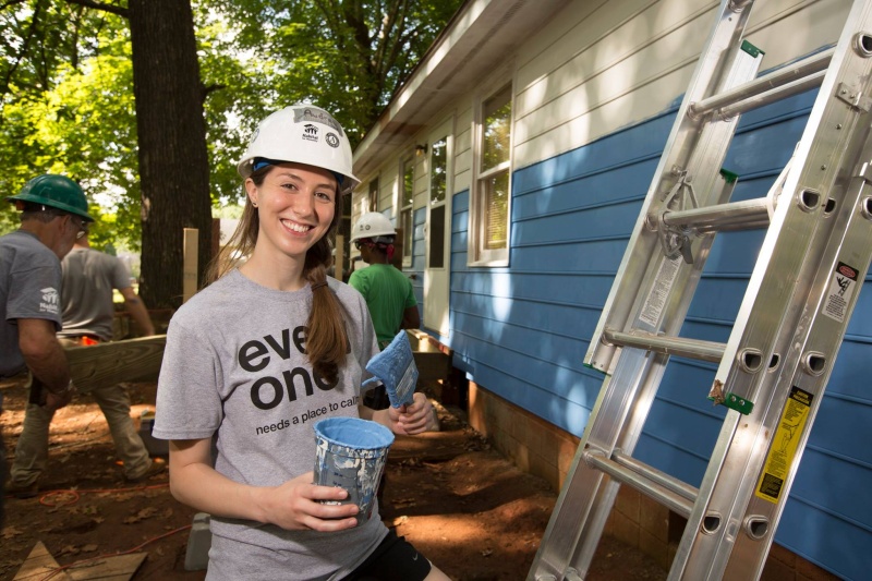 Habitat Wake volunteer paints the exterior of a home