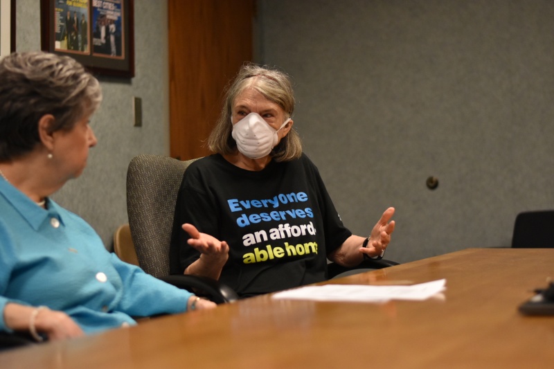 An elder woman with mask in dialogue with an elder elected representative