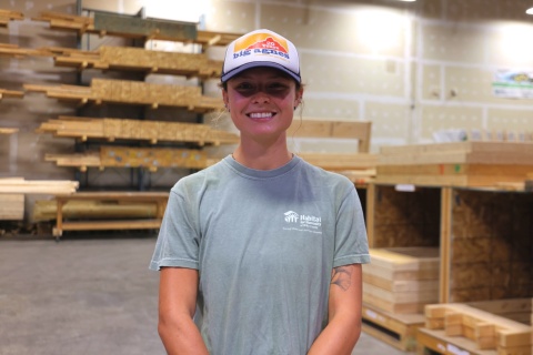 Kat, an AmeriCorps team members, stands in the Habitat Wake construction warehouse