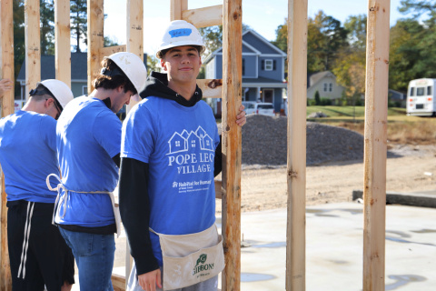 Student volunteer raises wall at construction site