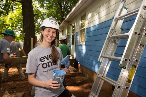 Habitat Wake volunteer paints the exterior of a home