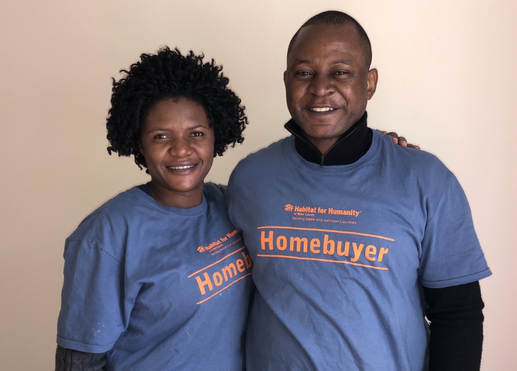 Two Habitat homeowners in blue shirts. 